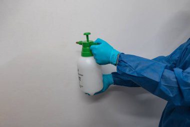 Takım elbiseli adam dezenfektan sıkar. konsept dezenfeksiyon