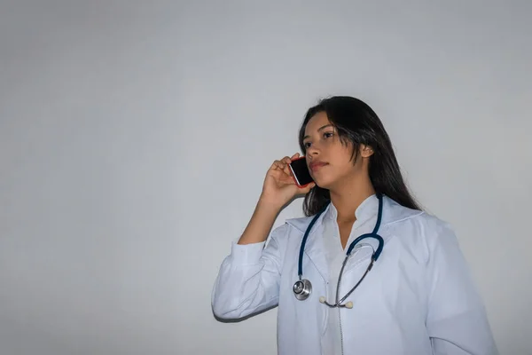 医生或护士通过手机呼叫 身穿长袍的妇女和戴听诊器的妇女与医生交谈 — 图库照片