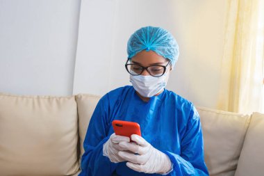 Siyahi kadın hemşire cep telefonundan mesajlarını kontrol ediyor. Akıllı telefon kullanan hastane çalışanının portresi