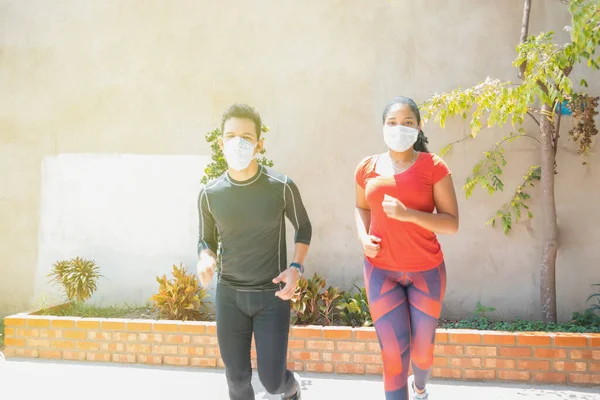 A young guy and a girl in medical masks run around on the playground during a pandemic. COVID-19. Health care.