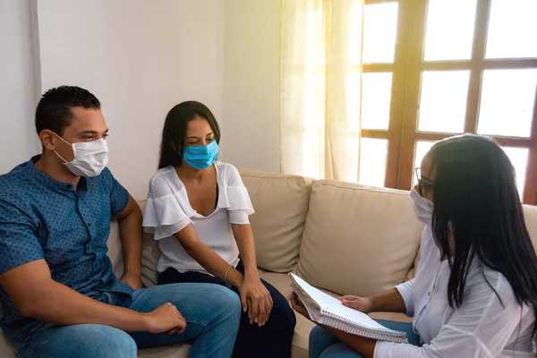 Sizin danışmanınıza (mal varlığı, parası ya da benzeri) sahip bir çift finansal planlama yapıyor - tıbbi maske takıyorlar