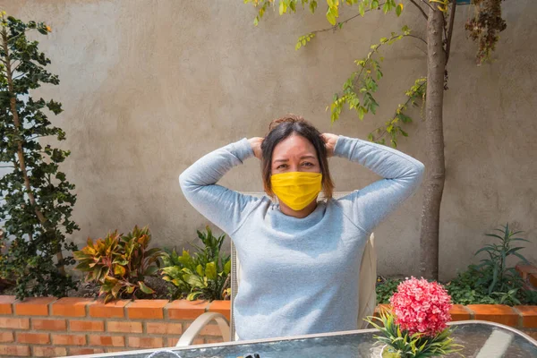 Mujer Sentada Jardín Poniéndose Mascarilla — Foto de Stock