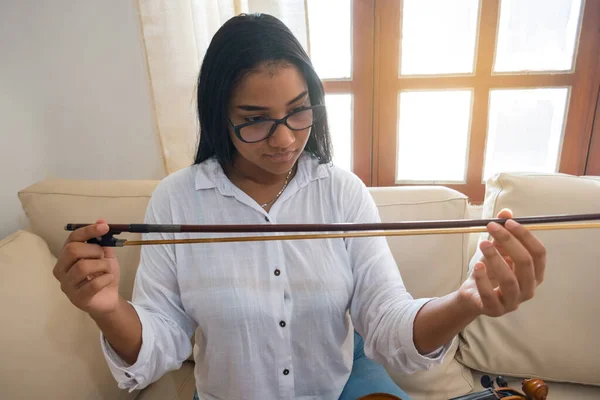 Kadın müzisyen kemanını ayarlıyor.