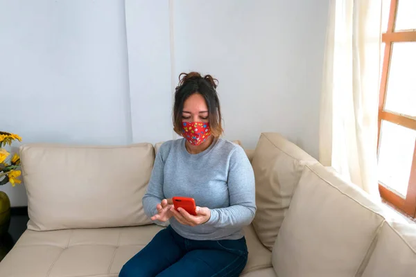 Mogen Kvinna Med Ansiktsmask Sittande Vardagsrummet Med Hjälp Mobiltelefon — Stockfoto