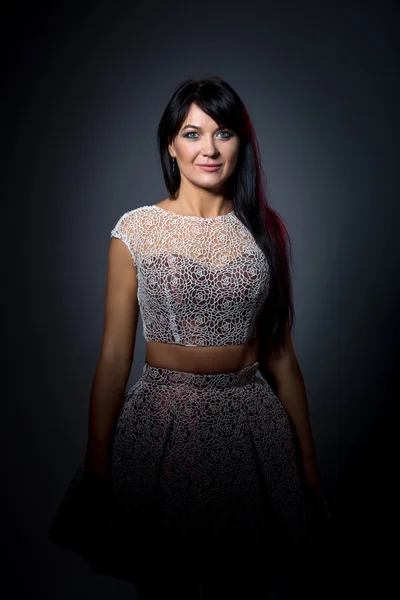 Hermosa mujer en un vestido de encaje en habitación oscura — Foto de Stock