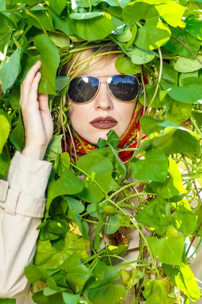 Retrato de moda em folhas selvagens de outono, fundo natural. Lindo rosto de mulher usando óculos de sol e lenço de cabeça — Fotografia de Stock