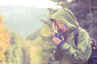 Gezgin İçecek sıcak çay veya kahve dağlarda sonbahar toplantı Sunrise ormandaki