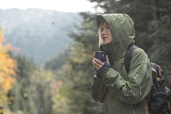 旅行者喝热茶或咖啡在森林里的但在秋季会议日出山 — 图库照片