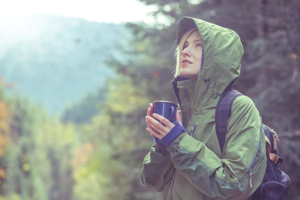 Podróżnik picia gorącej herbaty lub kawy w lesie jesienią — Zdjęcie stockowe