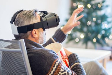 giyen sanal gerçeklik kulaklık evde oturan adam 