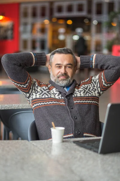 Człowiek siedzi w kawiarni pracę z laptopem — Zdjęcie stockowe