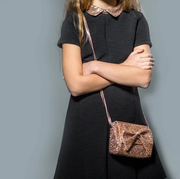 Young girl wearing black dress holding sparkling little hand bag — Stock Photo, Image