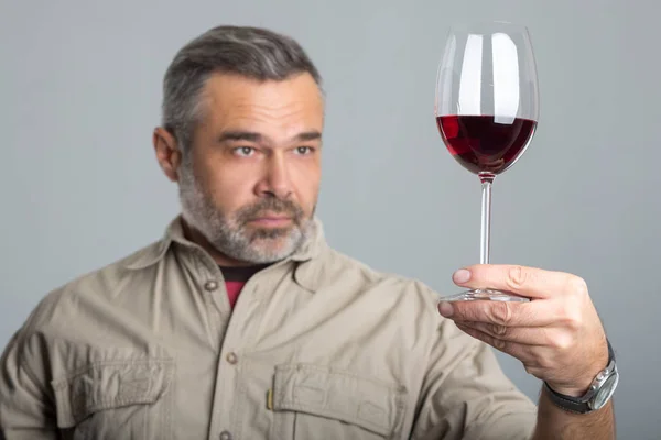 Gros plan vigneron inspecter le vin rouge dans le verre — Photo