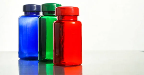 Färgglada piller behållare med reflektion — Stockfoto