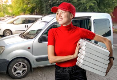 Pizza getiren kız car yakınındaki pizza kutularıyla holding 