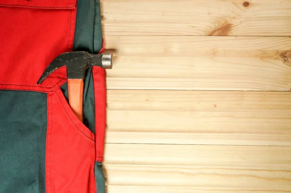 Hammer in a pocket of red and green boilersuit — Stock Photo, Image