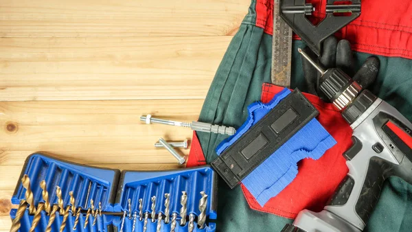 Ferramentas e roupas de trabalho na mesa — Fotografia de Stock