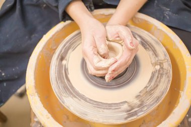 Toprak kap bir çanak çömlek tekerlek üzerinde yapma kadın