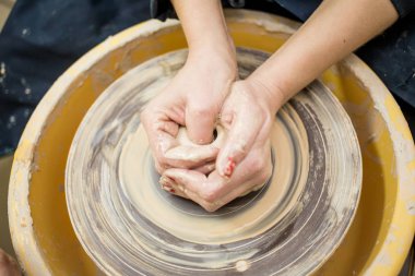 Toprak kap bir çanak çömlek tekerlek üzerinde yapma kadın