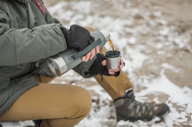 Adam bir termos çay dökülen