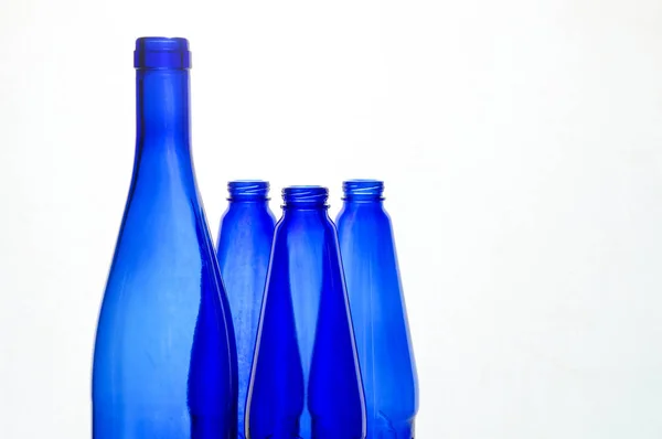 Blå flaskor över vita — Stockfoto