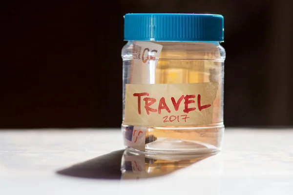 Travel budget concept. Travel money savings in a glass jar