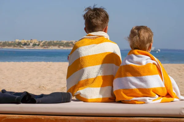 Two adorable children wrapped in towel after swimming at tropical beach — Stock Photo, Image