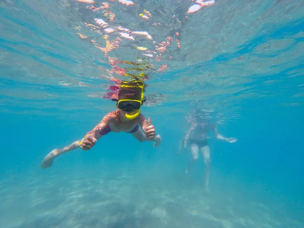 Mundo subaquático com meninos mergulhos nadando com peixes coloridos — Fotografia de Stock