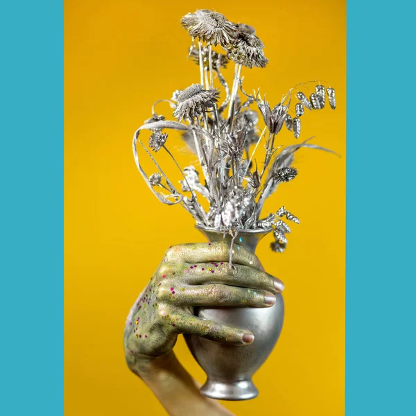 Blommor i en vas i en målad hand — Stockfoto