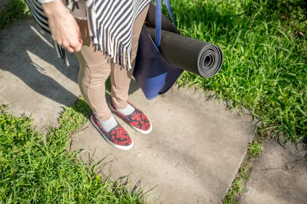 Pige med yogamåtte i parken på en forårsdag - Stock-foto