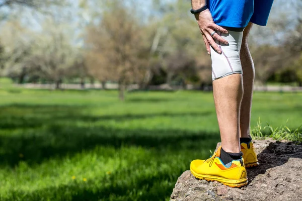 Knieschmerzen bei männlichen Läufern mit Verband — Stockfoto