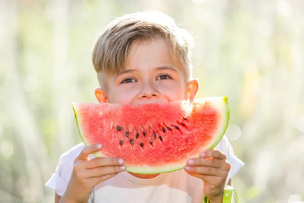 Lustiger verspielter Junge isst Wassermelone — Stockfoto