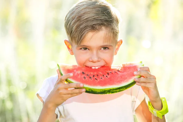 Lustiger verspielter Junge isst Wassermelone — Stockfoto