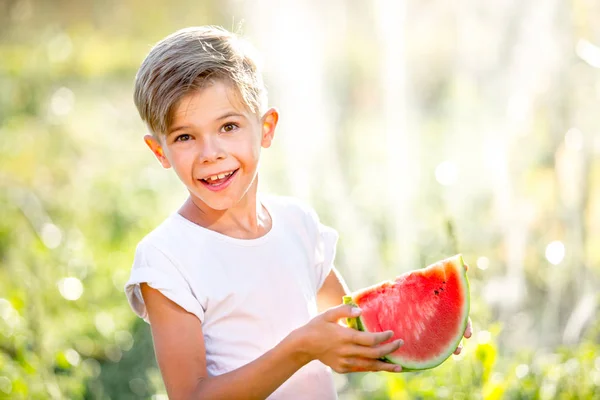 Divertente ragazzo giocoso mangiare anguria — Foto Stock