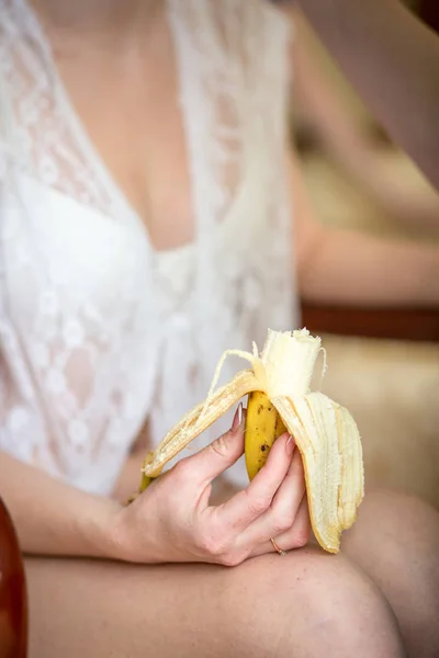 Woman eating banana, focus on hand — Stock Photo, Image