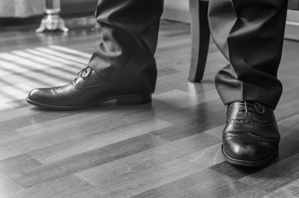Черно-белый образ человека, стоящего в элегантной обуви — стоковое фото