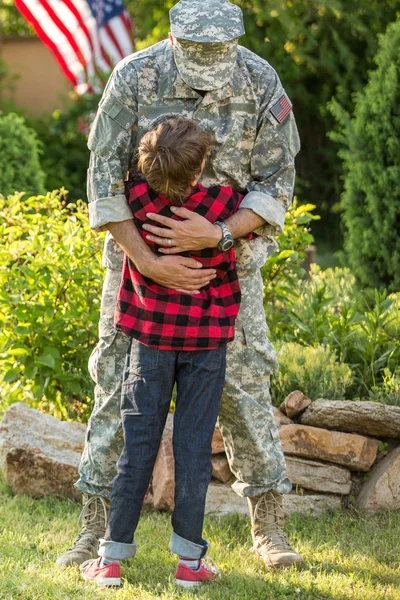 God gjenforening av soldat med familie utendørs på en solskinnsdag – stockfoto