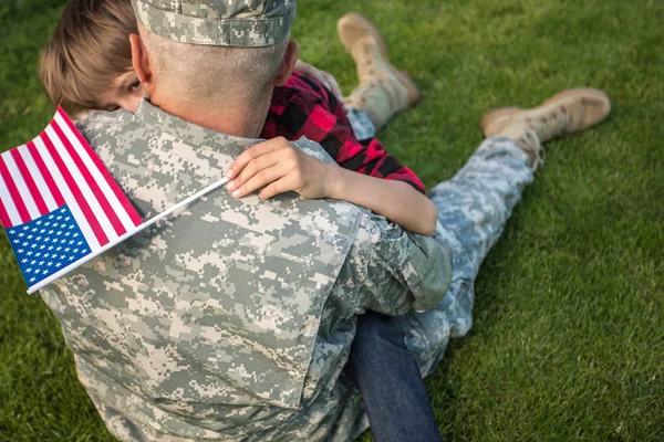 Gledelig gjenforening av soldat med familie utendørs på en solskinnsdag, far med sin sønn utendørs portrett – stockfoto