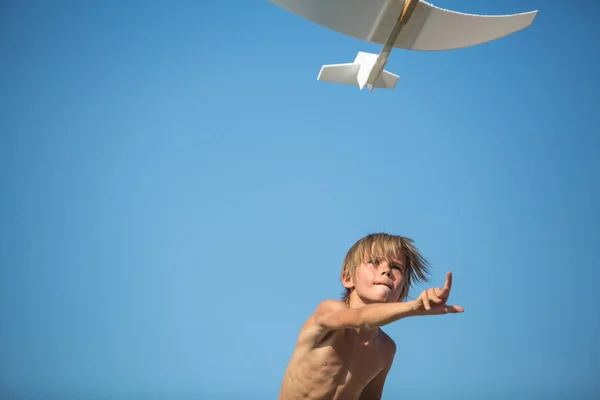 Мальчик с самолетом над голубым небом — стоковое фото