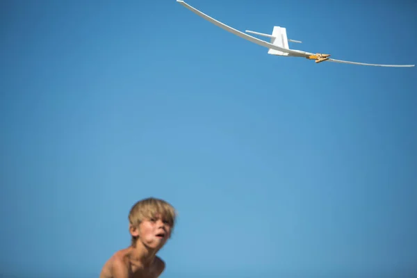Handgemaakte vlak over blauwe hemel met de jongen op de achtergrond — Stockfoto