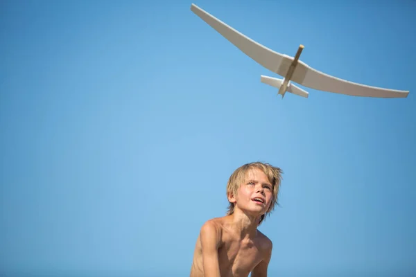 Jongen met vliegtuig over blauwe hemel — Stockfoto
