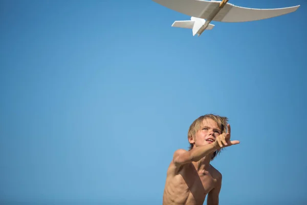 Jongen met vliegtuig over blauwe hemel — Stockfoto