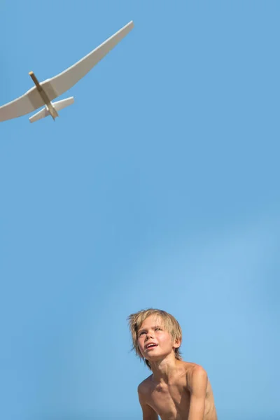 Garçon avec avion sur ciel bleu — Photo