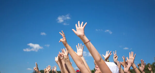 Группа счастливых молодых людей с поднятыми к небу руками — стоковое фото