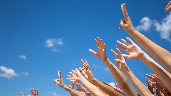 Grupo de jóvenes felices con las manos en el cielo — Foto de Stock