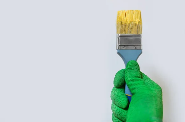 Adam sarı boya ile fırça tutar — Stok fotoğraf
