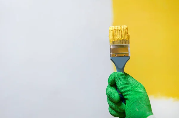 Adam sarı boya ile fırça tutar — Stok fotoğraf