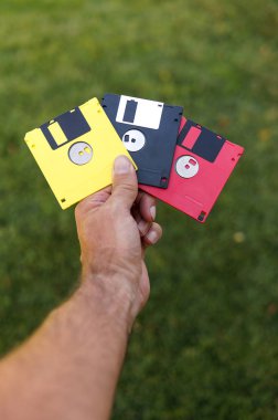 Disketleri adam yeşil çim arka plan üzerinde el