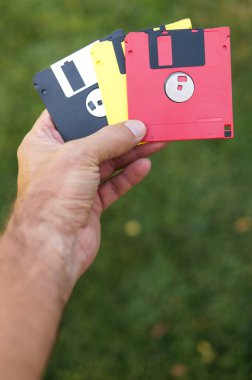 Disketleri adam yeşil çim arka plan üzerinde el