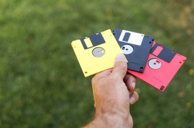 Disketleri adam yeşil çim arka plan üzerinde el